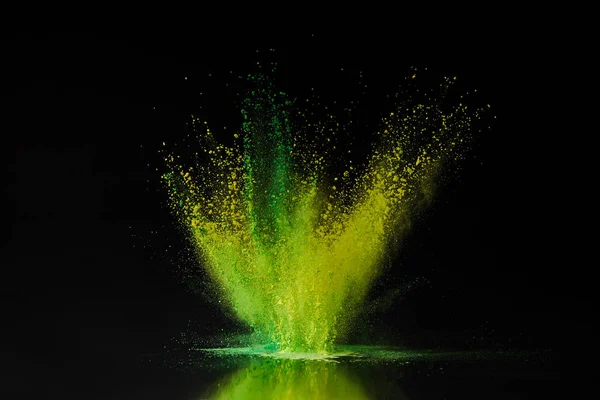 Esplosione di polvere di oli verdi e gialli sul nero, tradizionale festa indiana dei colori — Foto stock