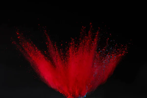 Explosión de polvo de holi rojo aislado en negro, festival de colores - foto de stock