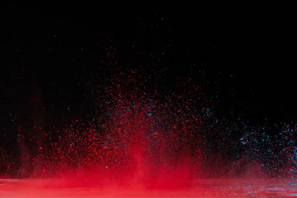 Red holi powder explosion on black, traditional festival of colours — Stock Photo