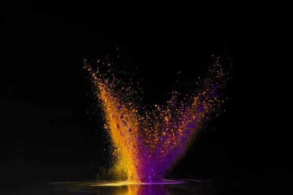 Explosión de polvo de holi naranja y púrpura en negro, festival hindú de primavera — Stock Photo