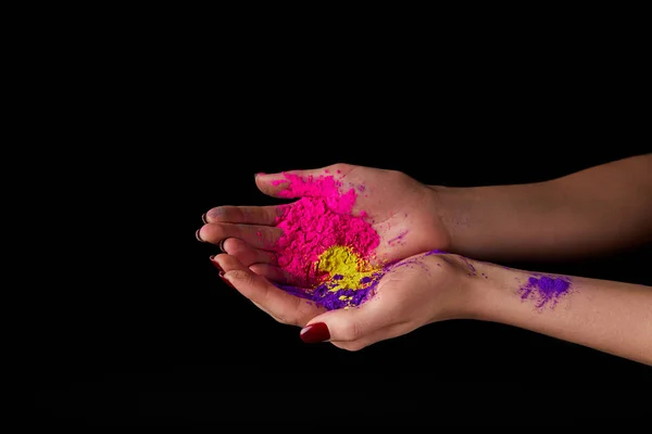 Vista ritagliata della donna che tiene in polvere per il festival dei colori, isolato sul nero — Foto stock