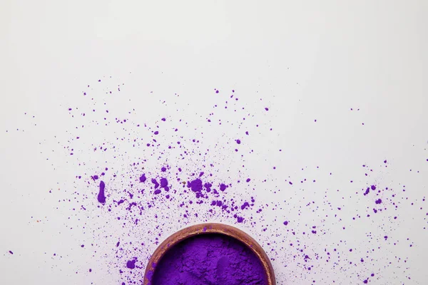 Vue du dessus de la peinture violette holi dans un bol isolé sur blanc, fête du printemps hindou — Photo de stock