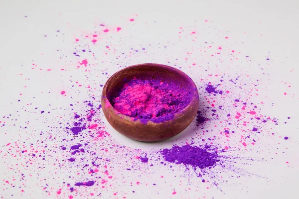 Poudre holi violet et rose dans un bol isolé sur blanc — Photo de stock