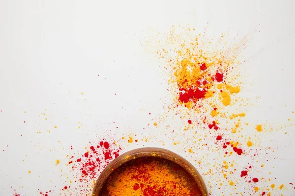 Top view of orange and red holi paint in bowl isolated on white — Stock Photo