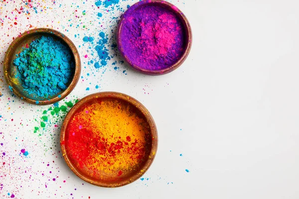 Vista dall'alto di colorata polvere tradizionale holi in ciotole isolate su bianco — Foto stock