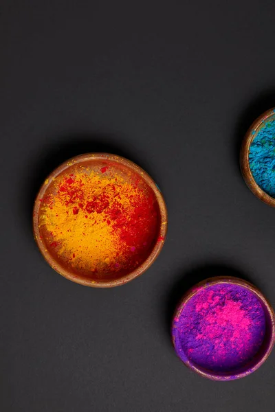 Vue de dessus de poudre holi colorée dans des bols sur la surface grise, festival de printemps hindou — Photo de stock