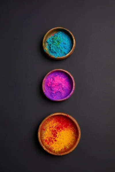 Вид сверху на красочные холи краски в чашах в ряд на серой поверхности — стоковое фото