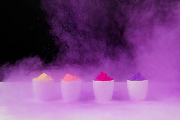 Row of tradition holi powder in bowls on black, Hindu spring festival of colours — Stock Photo