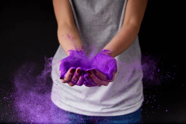 Vue recadrée de la personne avec de la peinture holi violet, isolé sur noir — Photo de stock