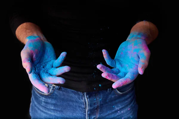 Обрезанный вид человека с синей традиционной краской цвета голи на руках, изолированный на черном — стоковое фото