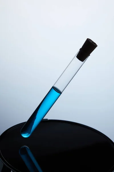 Tubo de ensayo lleno de líquido azul en el soporte trasero — Stock Photo