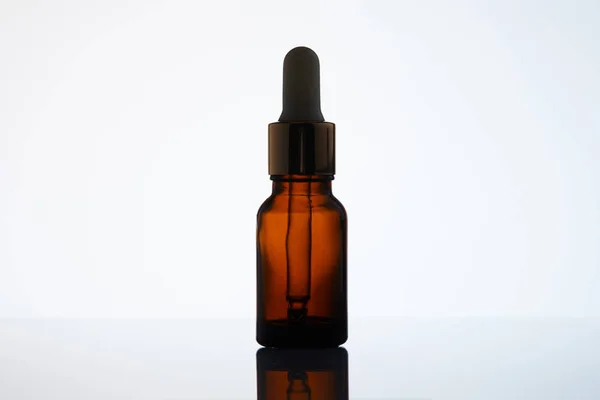 Primer plano de la botella de aceite aromático con pipeta en la superficie reflectante - foto de stock