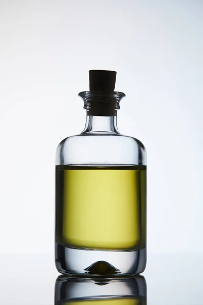 Botella cerrada de aceite de masaje aromático de pie en la superficie reflectante - foto de stock