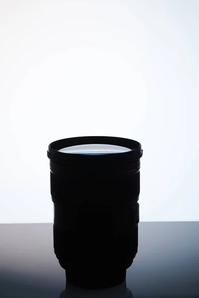 Single camera lens silhouette on white — Stock Photo