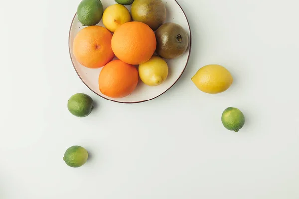 Top view of juicy citruses on plate isolated on white background — Stock Photo