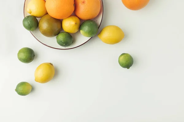 Juicy citruses on plate isolated on white background — Stock Photo