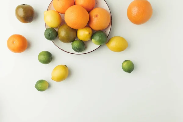 Citrus fruits on plate isolated on white background — Stock Photo