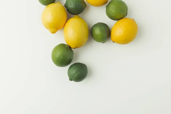 Limas verdes y limones aislados sobre fondo blanco - foto de stock