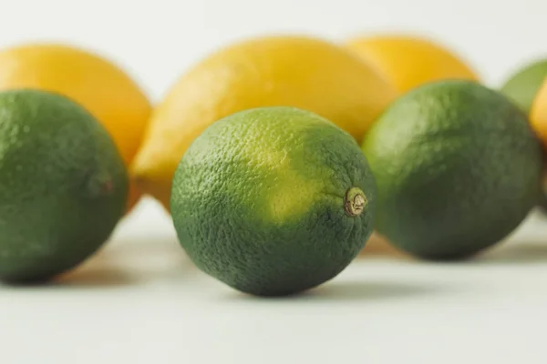 Limas crudas y limones aislados sobre fondo blanco - foto de stock