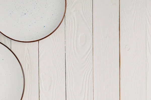 Ceramic beautiful plates on white wooden background — Stock Photo