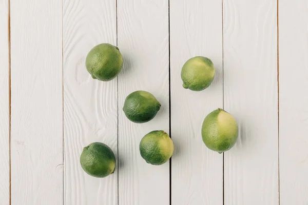 Limes grecques sur fond blanc en bois — Photo de stock