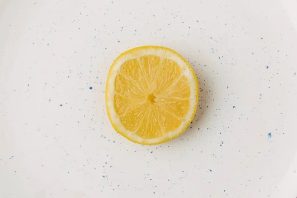 Half of juicy lemon on glazed plate — Stock Photo