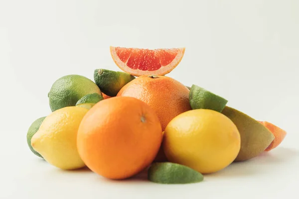 Rebanada de pomelo sobre un montón de cítricos aislados sobre fondo blanco - foto de stock