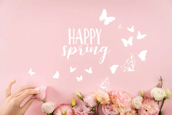 Vista superior de la mano la organización de hermosas flores tiernas con el signo de PRIMAVERA FELIZ y mariposas aisladas sobre fondo rosa - foto de stock