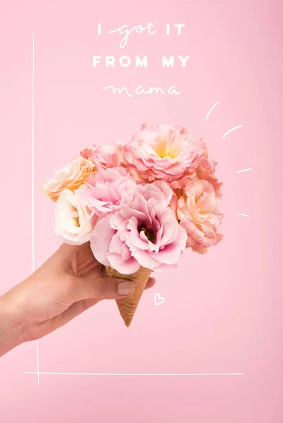 Mothers day greting card with person holding waffle cone with beautiful blooming flowers isolated on pink — Stock Photo