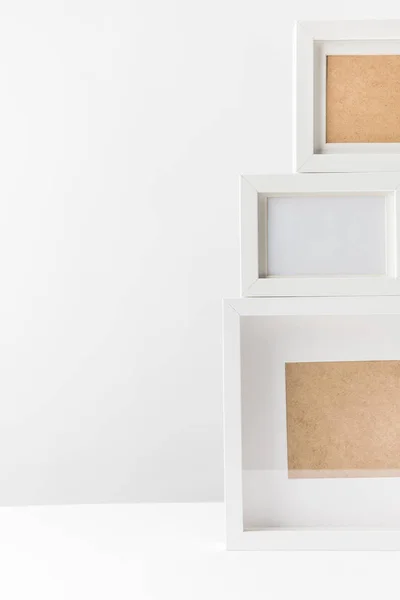 Close-up view of empty white photo frames on white — Stock Photo
