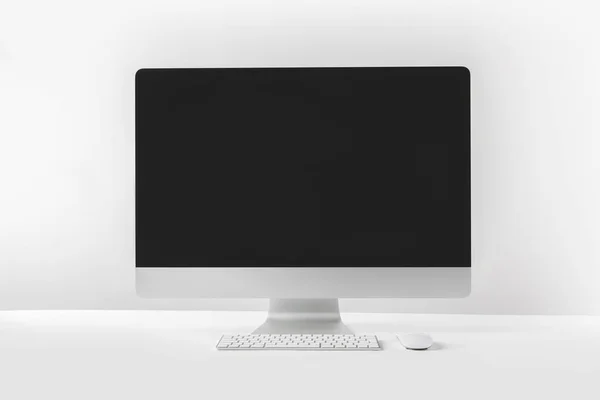 Modern desktop computer with blank screen on white — Stock Photo