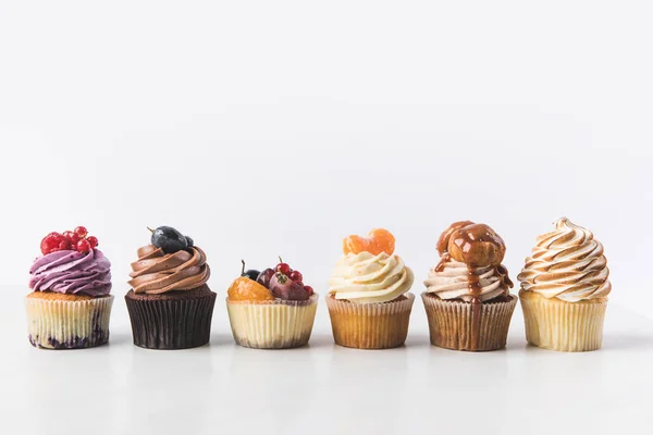 Vue rapprochée de divers cupcakes sucrés isolés sur blanc — Photo de stock