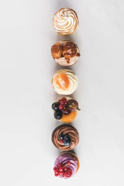 Vue de dessus de l'arrangement des cupcakes savoureux isolés sur blanc — Photo de stock