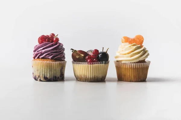 Nahaufnahme von verschiedenen süßen Cupcakes isoliert auf weiß — Stockfoto