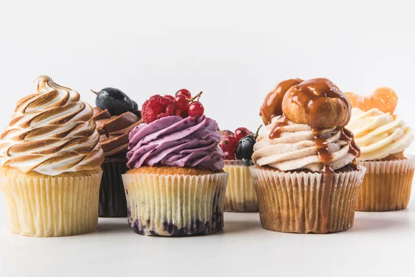 Nahaufnahme von verschiedenen süßen Cupcakes isoliert auf weiß — Stockfoto