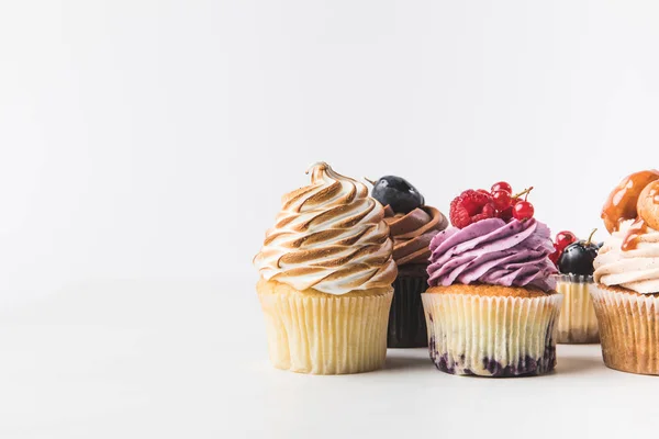 Vista de perto de vários cupcakes doces isolados em branco — Fotografia de Stock