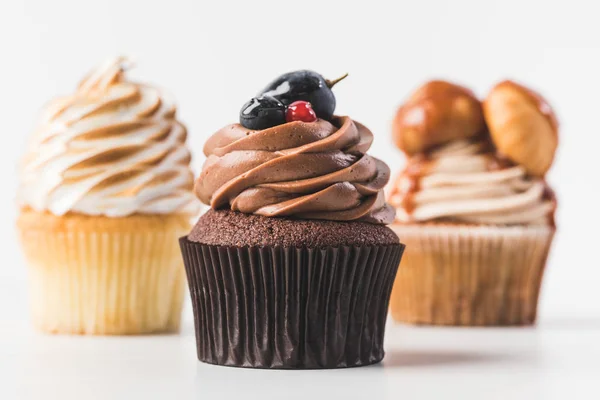 Foco seletivo de cupcakes doces com creme isolado em branco — Fotografia de Stock