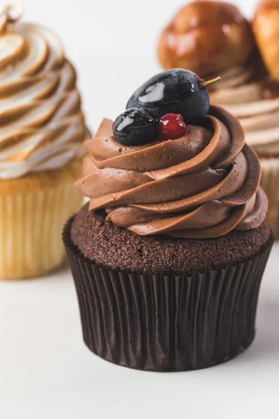 Focalizzazione selettiva di cupcake dolci con crema isolata su bianco — Foto stock