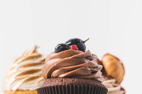 Foco seletivo de cupcakes doces com creme isolado em branco — Fotografia de Stock