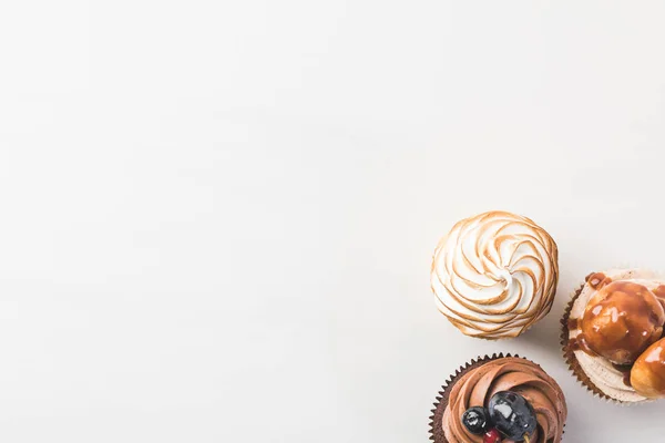 Ansicht von oben nach Anordnung von leckeren Cupcakes isoliert auf weiß — Stockfoto