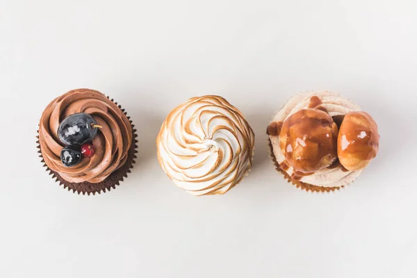 Vista superior de arranjo de cupcakes saborosos isolados em branco — Fotografia de Stock