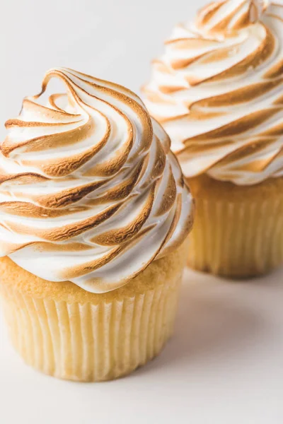 Vista de cerca de magdalenas dulces con merengue aislado en blanco - foto de stock