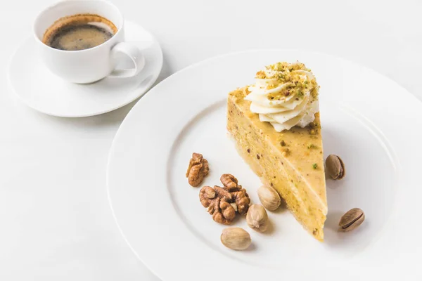 Close up view of piece of cake with nuts and cup of coffee isolated on white — Stock Photo