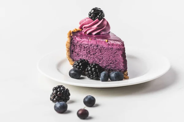Закрыть вид на черничный пирог со свежими ягодами на тарелке, изолированной на белом — стоковое фото