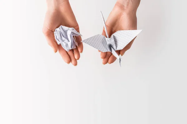 Tiro recortado de mujer sosteniendo pelota y pájaro hecho de papel en manos aisladas en gris, medio ambiente y concepto de reciclaje - foto de stock
