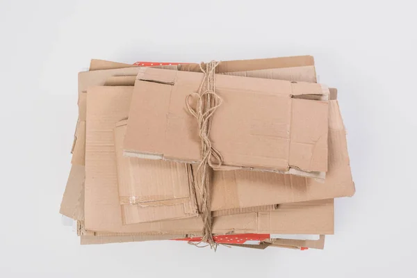 Vista superior de la pila de cajas de cartón plegadas aisladas en gris, concepto de reciclaje - foto de stock