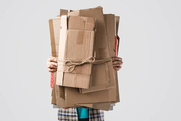 Cropped shot of man holding pile of folded cardboard boxes isolated on grey, recycling concept — Stock Photo