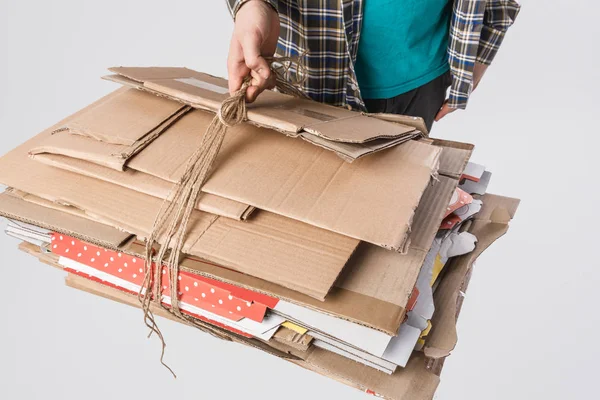Cropped shot of man holding pile of folded cardboard boxes isolated on grey, recycling concept — Stock Photo
