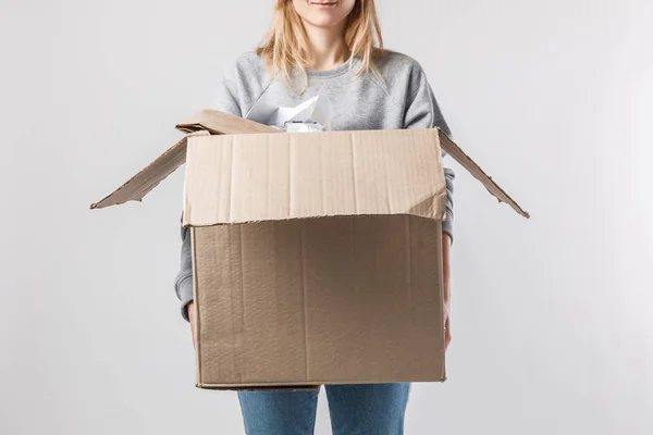 Vista parcial de la mujer sosteniendo caja de cartón con basura en las manos, concepto de reciclaje - foto de stock