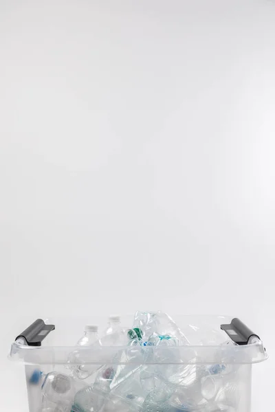 Vista de cerca del contenedor con botellas de plástico aisladas en gris, concepto de reciclaje - foto de stock